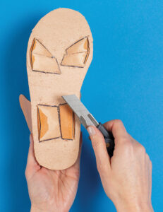 skiving tabs with sharp knife on bottom of sandal sole